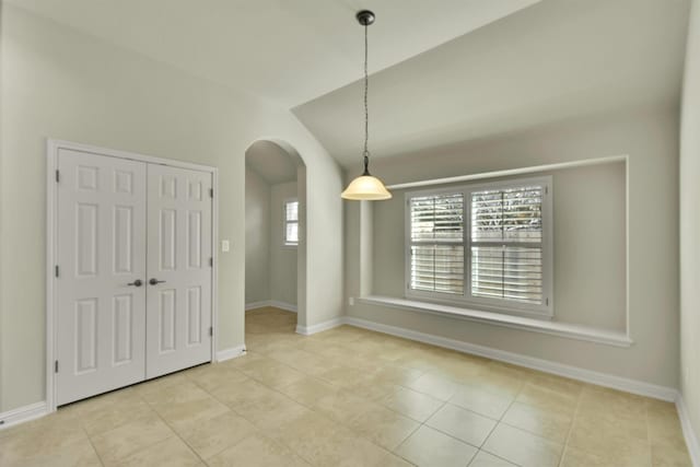 tiled spare room with lofted ceiling