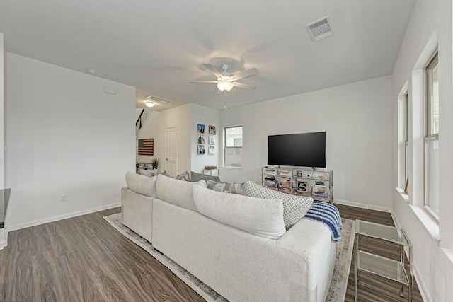 living room featuring dark wood-type flooring and ceiling fan