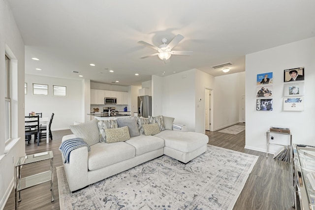 living room featuring wood-type flooring and ceiling fan