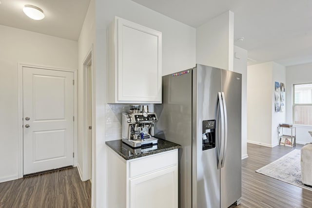 kitchen featuring stainless steel refrigerator with ice dispenser, dark wood-type flooring, dark stone countertops, and white cabinets