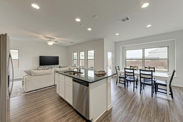 kitchen featuring appliances with stainless steel finishes, dark hardwood / wood-style floors, white cabinetry, an island with sink, and sink