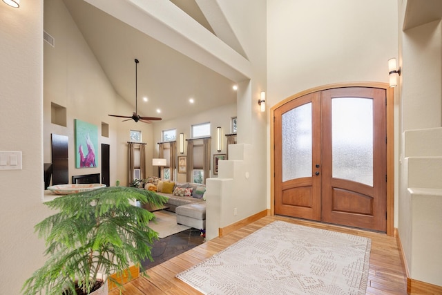 foyer entrance featuring french doors, high vaulted ceiling, and hardwood / wood-style floors