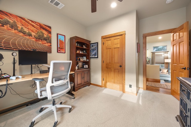 carpeted home office featuring ceiling fan