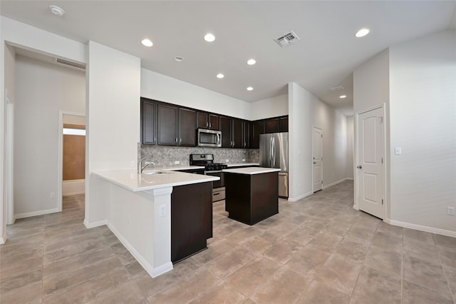 kitchen with sink, decorative backsplash, dark brown cabinetry, kitchen peninsula, and stainless steel appliances