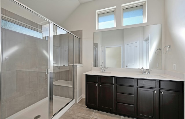 bathroom featuring vanity, vaulted ceiling, tile patterned floors, and a shower with shower door