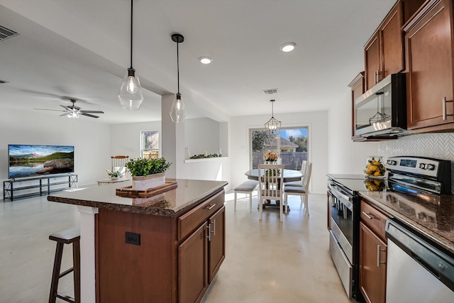 kitchen with pendant lighting, a healthy amount of sunlight, appliances with stainless steel finishes, and a center island