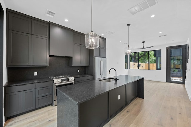 2010 Gathright Unit B, Austin, TX 78704 - kitchen with stainless steel appliances, recessed lighting, dark stone counters, an island with sink, and light wood-style flooring
