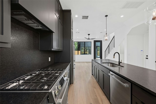 2010 Gathright Unit B, Austin, TX 78704 - kitchen with appliances with stainless steel finishes, extractor fan, light wood-type flooring, dark countertops, and recessed lighting
