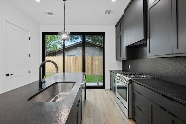 2010 Gathright Unit B, Austin, TX 78704 - kitchen with stainless steel gas stove, dark countertops, light wood finished floors, hanging light fixtures, and recessed lighting