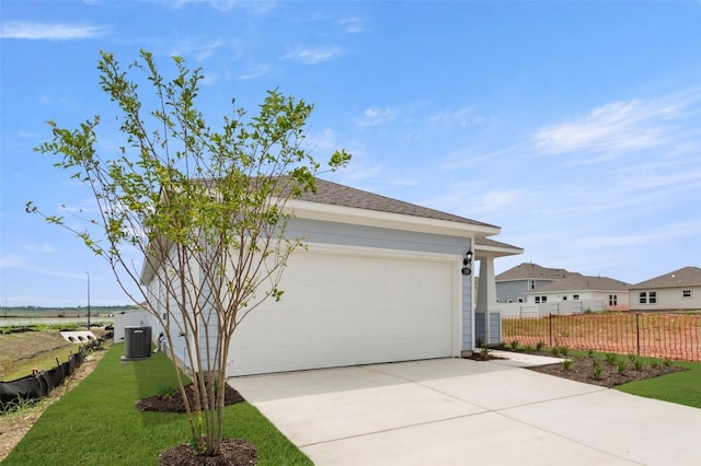 199 Lavender Ln, Elgin, TX 78621 - view of home's exterior with central AC, a yard, fence, and concrete driveway
