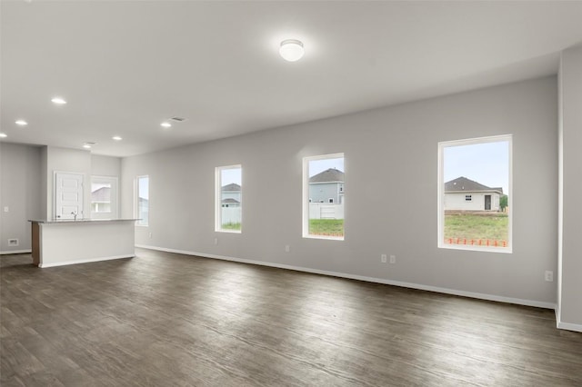 199 Lavender Ln, Elgin, TX 78621 - unfurnished living room with dark wood finished floors, baseboards, and recessed lighting