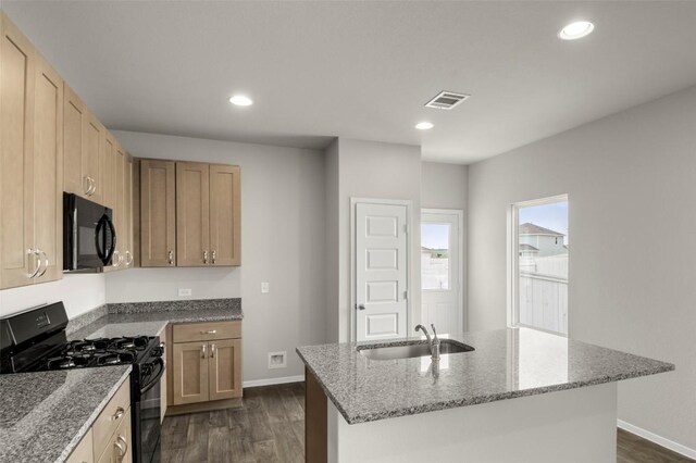199 Lavender Ln, Elgin, TX 78621 - kitchen featuring dark wood-style flooring, light stone counters, visible vents, a sink, and black range with gas stovetop