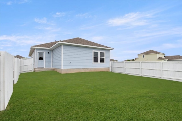 199 Lavender Ln, Elgin, TX 78621 - back of property with a fenced backyard, roof with shingles, and a yard