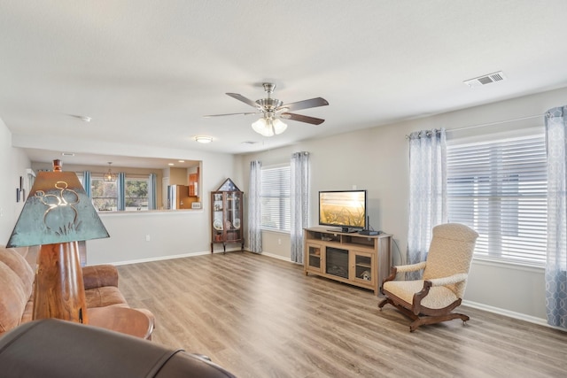 living room with ceiling fan and light hardwood / wood-style flooring