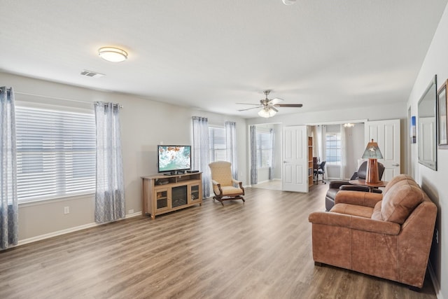 living room with hardwood / wood-style flooring, ceiling fan, and a wealth of natural light