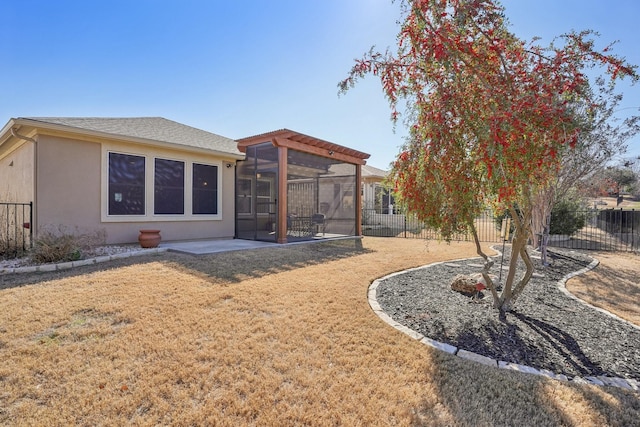 back of house with a yard, a patio area, and a sunroom