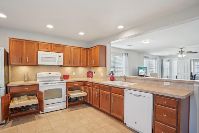 kitchen with light tile patterned flooring, sink, kitchen peninsula, white appliances, and decorative backsplash