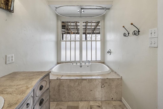 bathroom featuring vanity and tiled bath