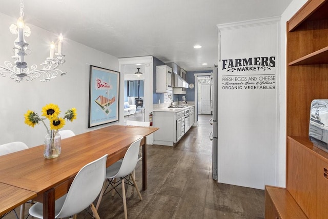 kitchen with sink, an inviting chandelier, dark hardwood / wood-style floors, white cabinets, and decorative light fixtures