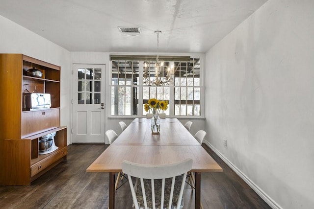 dining area with a notable chandelier and dark hardwood / wood-style flooring