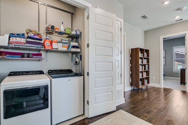 clothes washing area with dark hardwood / wood-style flooring and washing machine and dryer