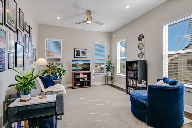 carpeted living room with ceiling fan