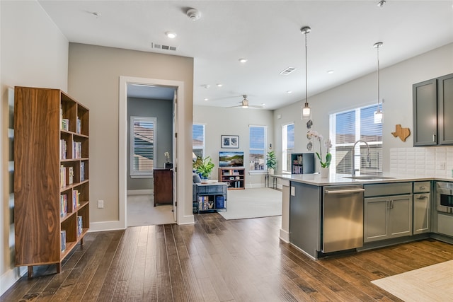 kitchen with sink, tasteful backsplash, hanging light fixtures, dark hardwood / wood-style floors, and dishwasher