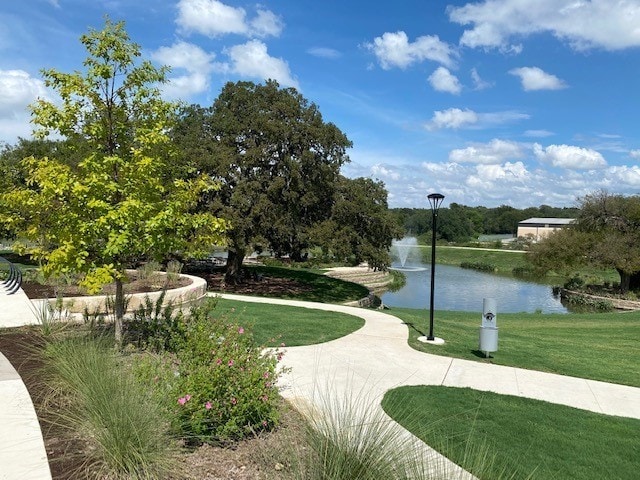 surrounding community with a yard and a water view
