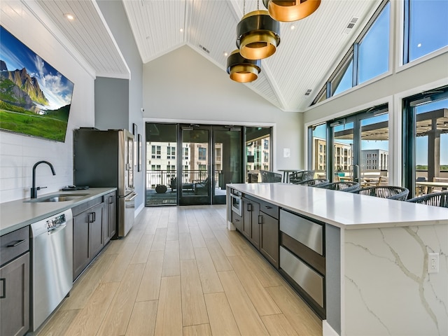 kitchen featuring sink, wood ceiling, stainless steel appliances, light stone countertops, and light wood-type flooring