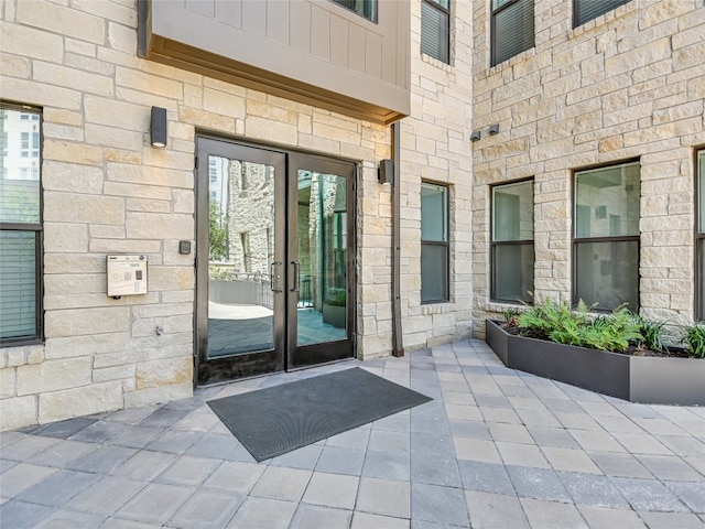 property entrance featuring stone siding and french doors
