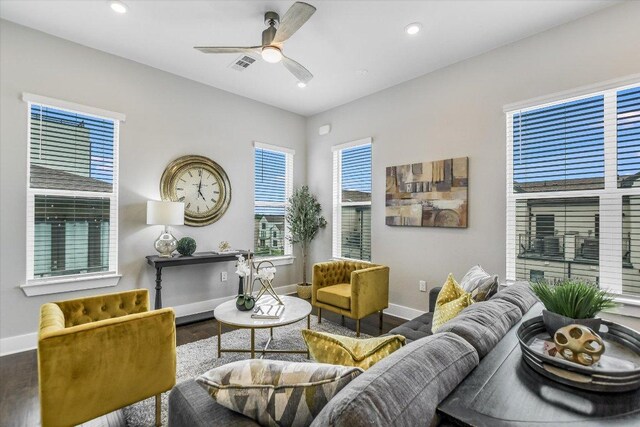 interior space featuring a ceiling fan, visible vents, wood finished floors, and baseboards