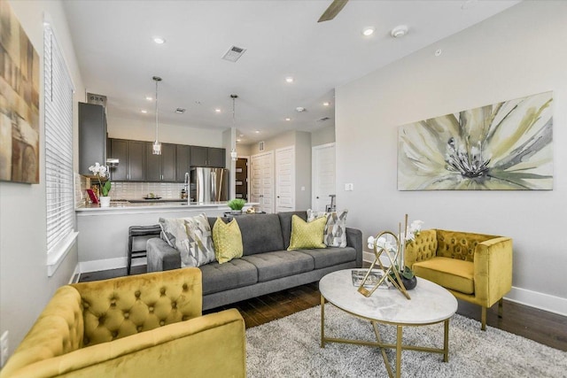 living area featuring baseboards, visible vents, wood finished floors, and recessed lighting