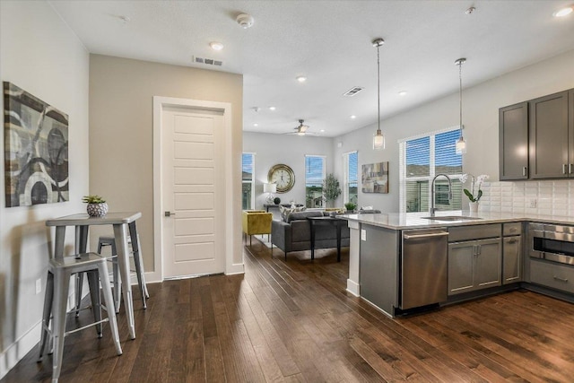 kitchen featuring dark wood-style floors, open floor plan, dishwasher, and a sink