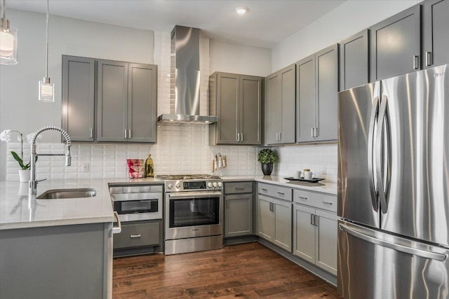 kitchen with wall chimney exhaust hood, a sink, stainless steel appliances, and gray cabinets