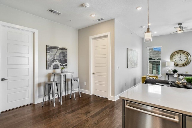 kitchen featuring visible vents, a ceiling fan, stainless steel dishwasher, and dark wood-type flooring