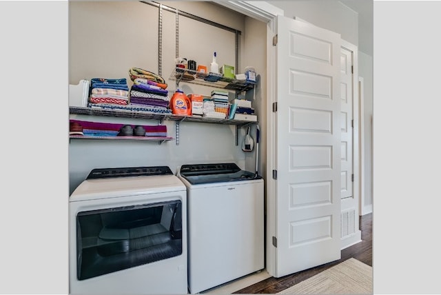 washroom with wood finished floors, washer and clothes dryer, and laundry area