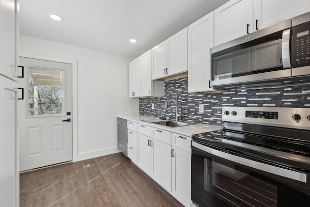 kitchen with appliances with stainless steel finishes, dark hardwood / wood-style flooring, sink, and white cabinets