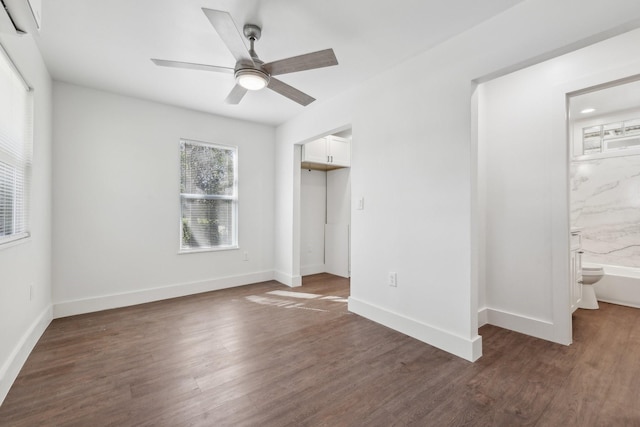 unfurnished bedroom with dark hardwood / wood-style floors, connected bathroom, and ceiling fan