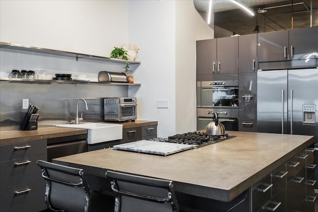 kitchen featuring stainless steel appliances, a breakfast bar area, sink, and a kitchen island