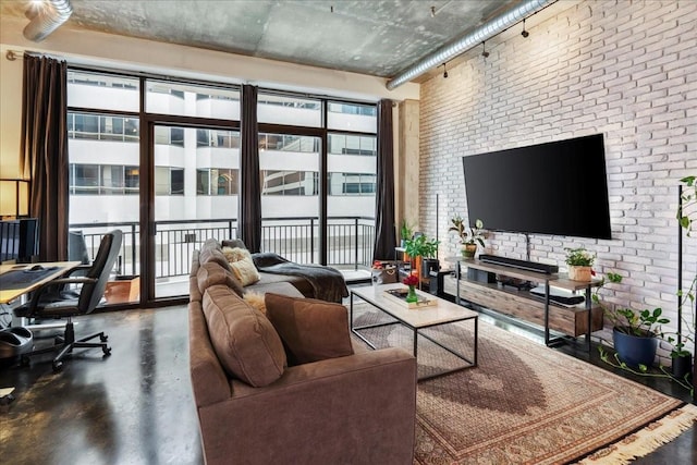 living room featuring brick wall and concrete floors