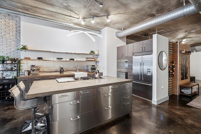 kitchen with appliances with stainless steel finishes, a kitchen breakfast bar, and a kitchen island