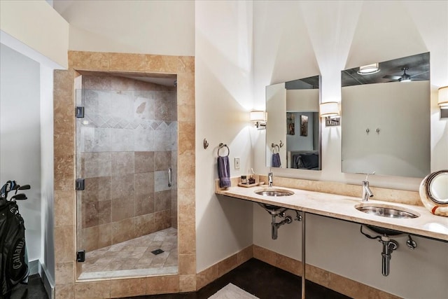 bathroom featuring double sink, tile patterned floors, and a shower with shower door