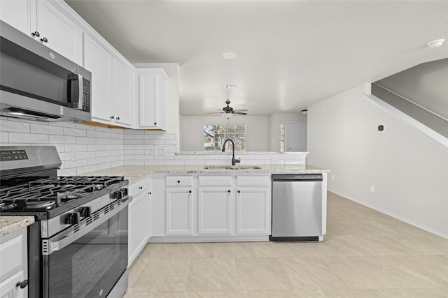 kitchen featuring light stone countertops, appliances with stainless steel finishes, sink, and white cabinets