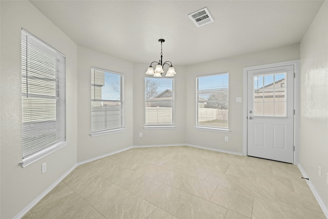 unfurnished dining area featuring an inviting chandelier and light tile patterned floors