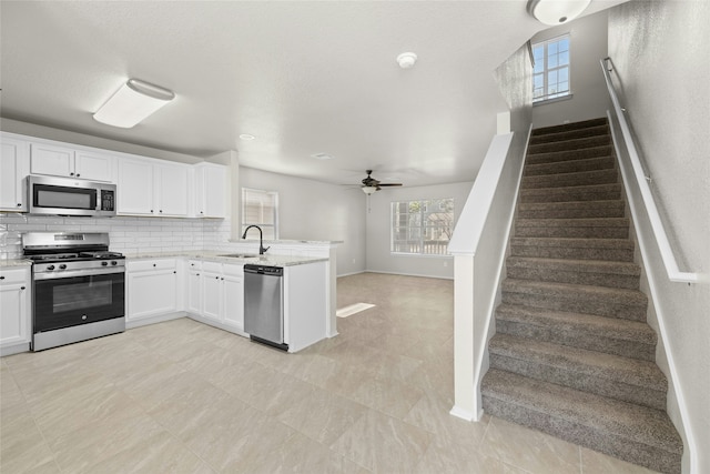 kitchen featuring appliances with stainless steel finishes, sink, white cabinets, and decorative backsplash