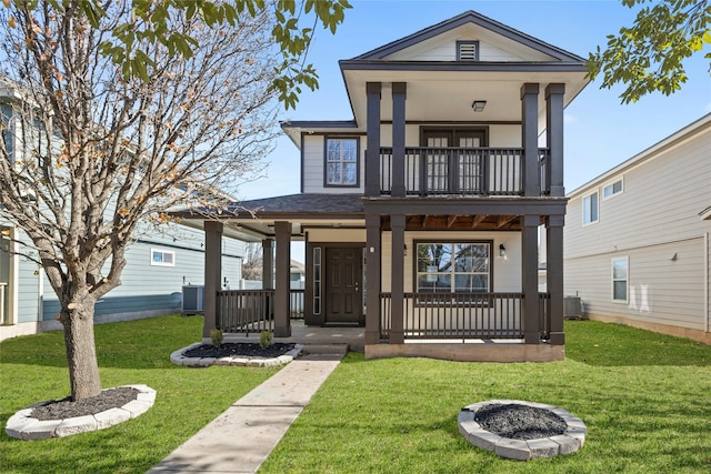 view of front of home with central AC unit, a front yard, and covered porch