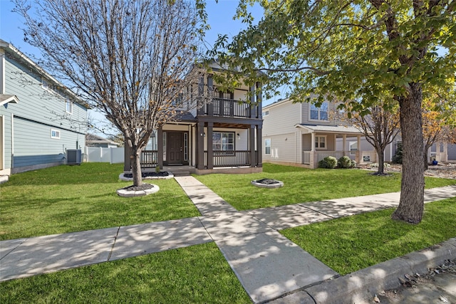 view of front of property with central AC, a front yard, and a balcony