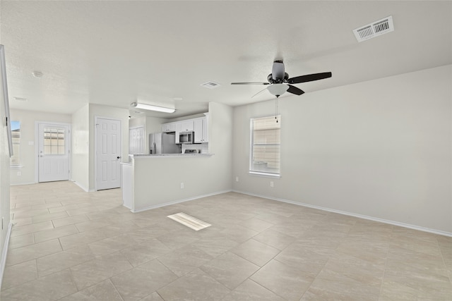 unfurnished living room with ceiling fan and light tile patterned flooring