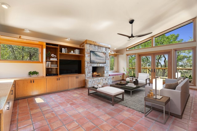 living room with french doors, vaulted ceiling, light tile patterned floors, ceiling fan, and a fireplace