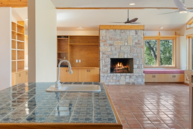 212 Comanche Cp, Kyle, TX 78640 - kitchen with ceiling fan, a sink, a fireplace, tile patterned floors, and recessed lighting